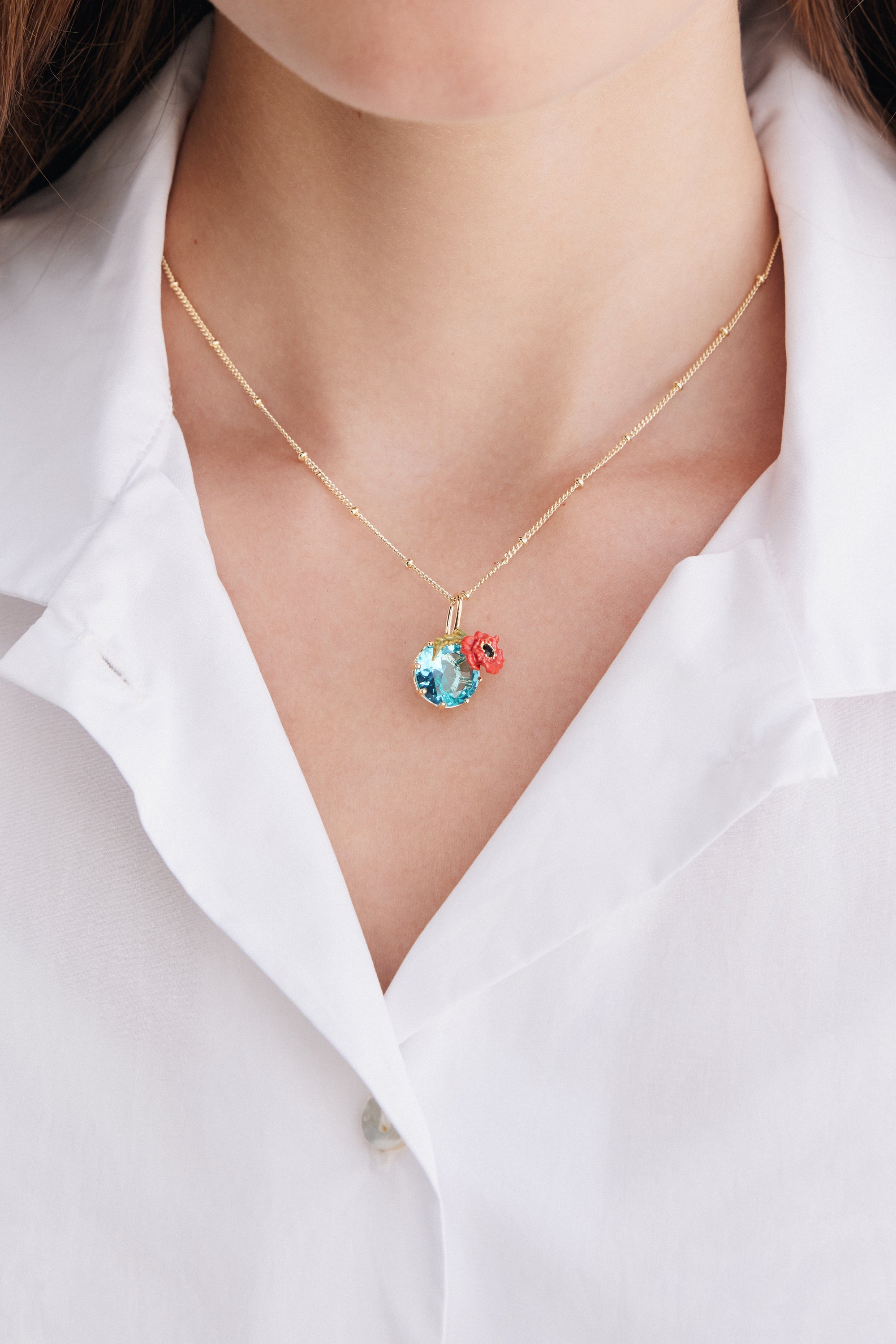 Pendant necklace with round blue stone and poppie