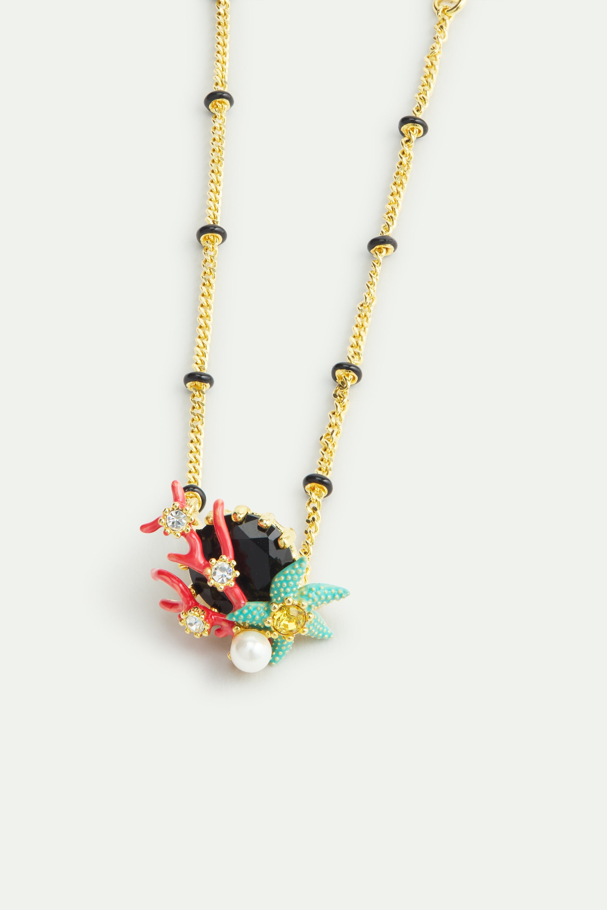 Fine bracelet with black round faceted stone, red coral, blue starfish and cultured pearl