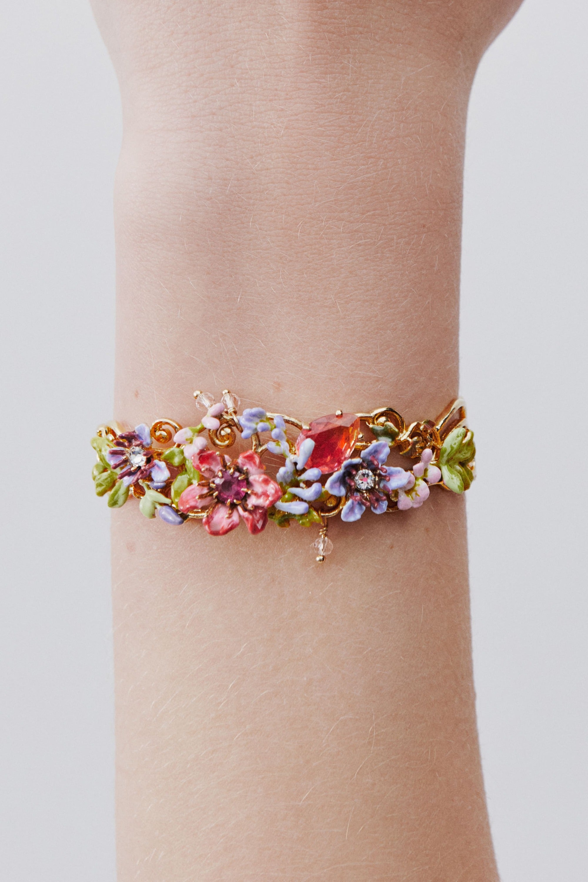 Cuff bracelet with pink and purple arabesque, ivy, pink and purple clematis, and two-tone faceted glass.