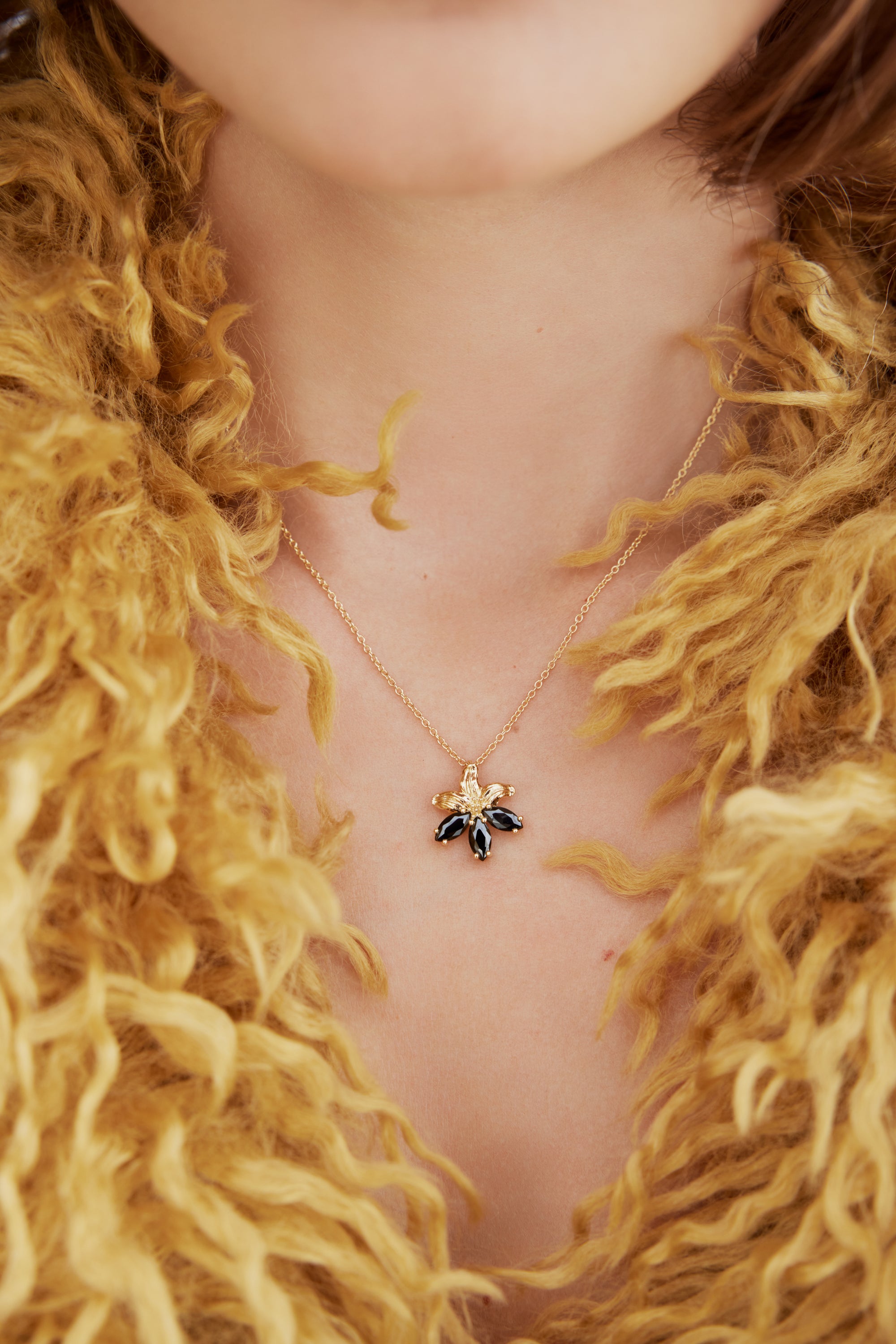 Golden lily and black stone pendant necklace