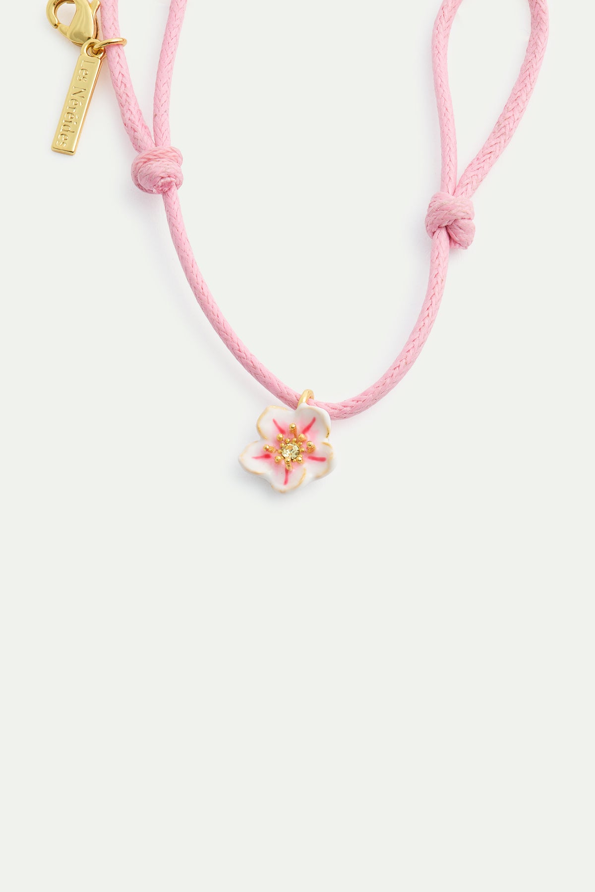 Pink thread bracelet with a tiny white cherry blossom