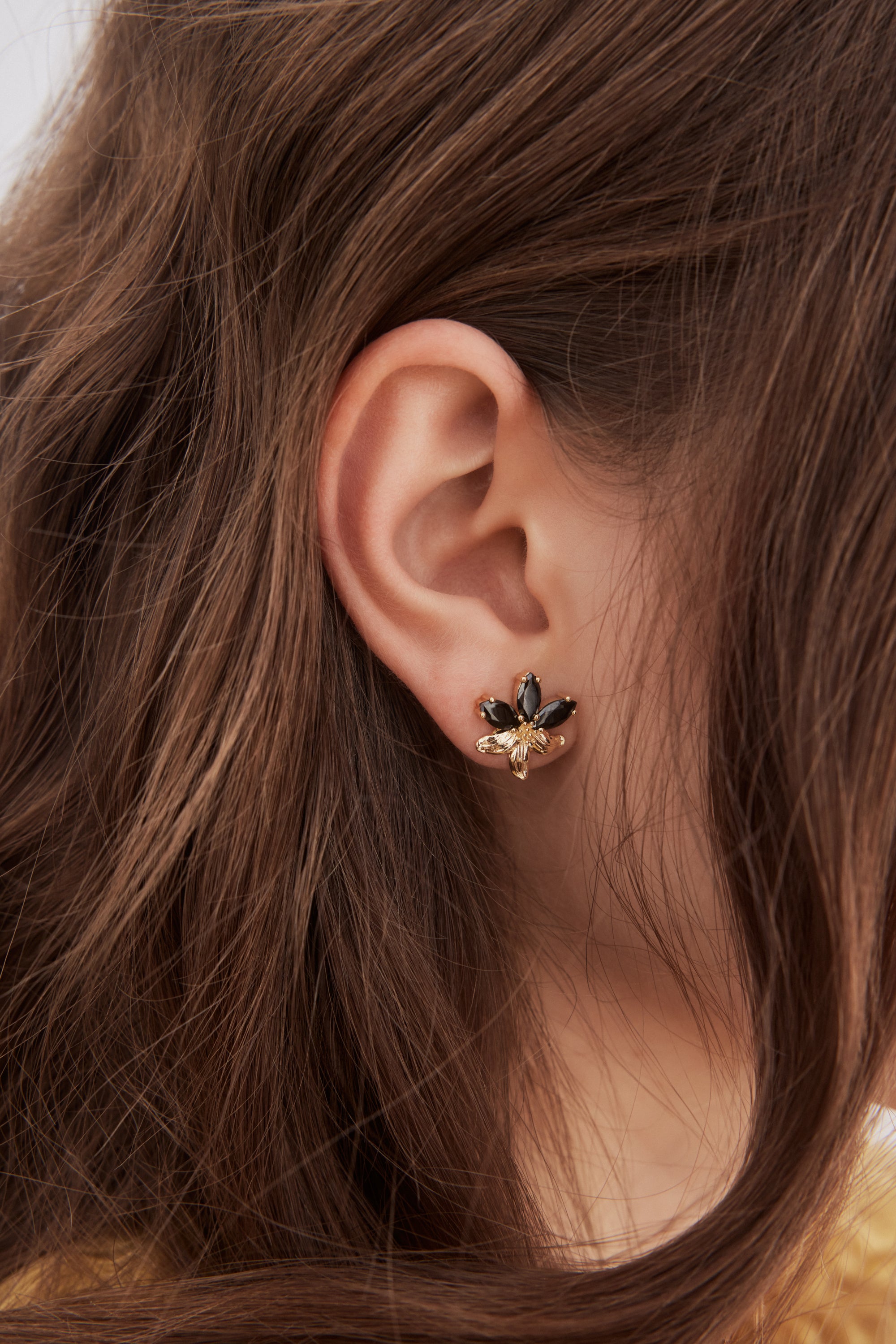 Golden lily and black stone post earrings